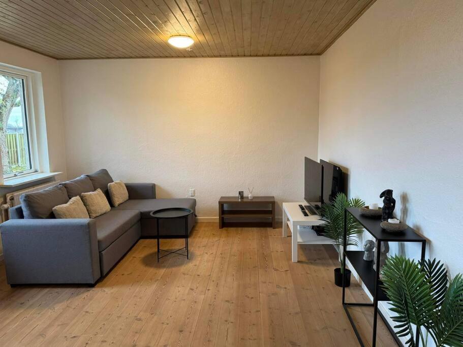 a living room with a couch and a tv at House Living Billund in Billund
