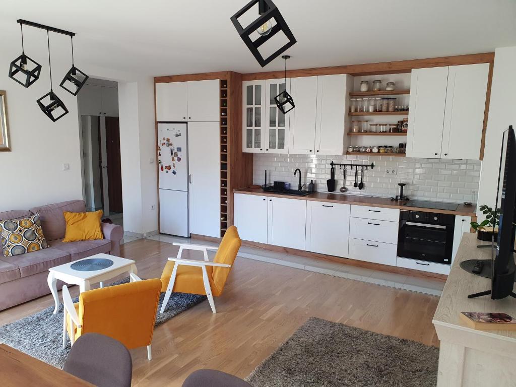 a kitchen and living room with a couch and a table at Apartment Noa in Tuzla