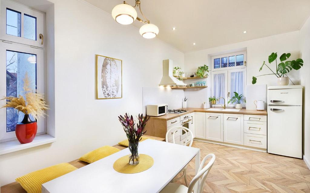 uma cozinha com uma mesa e cadeiras e um frigorífico branco em Bonton Apartments em Kežmarok