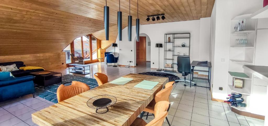 a living room with a wooden table and chairs at Stylish loft with balcony, quiet and spacious in Unterschleißheim