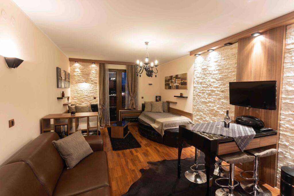 a living room with a couch and a bed at Apartman W Residence in Kopaonik