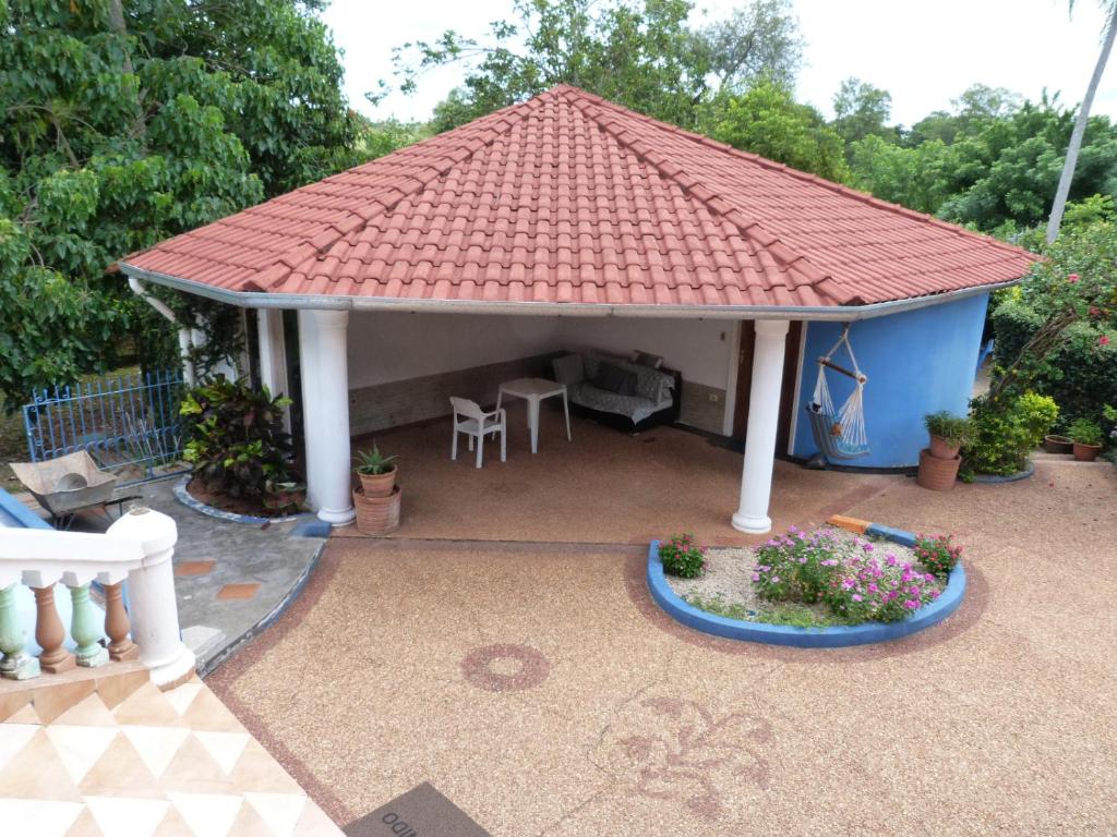 einen Pavillon mit rotem Dach auf einer Terrasse in der Unterkunft Casa-Miri in Piribebuy