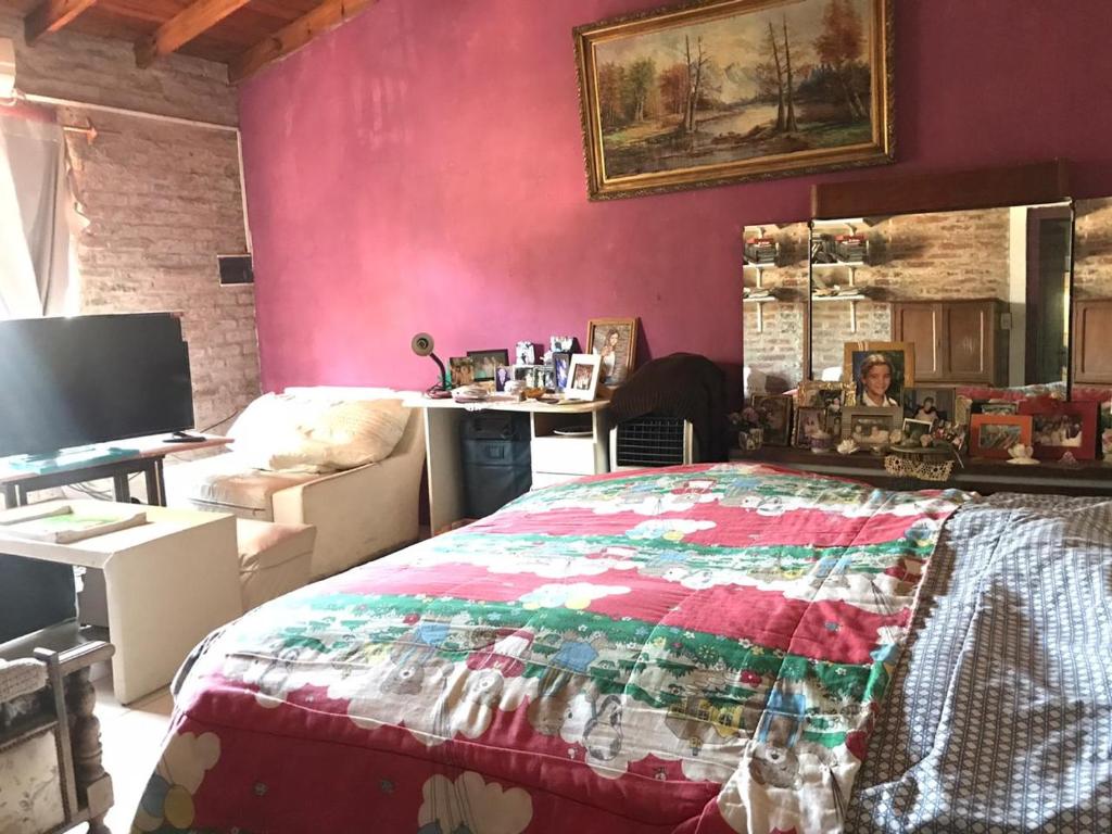 - une chambre avec un lit et un mur rose dans l'établissement Mi Bella Vista - Quinta Con Pileta, à Bella Vista
