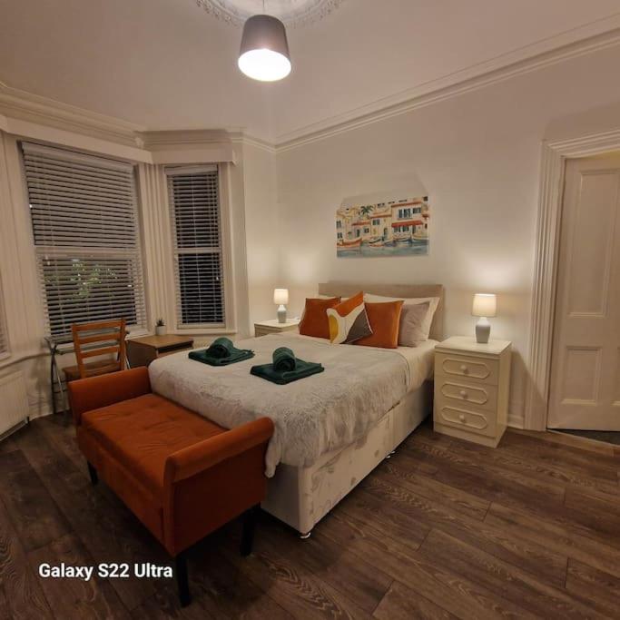 a bedroom with a large bed and a chair at 4 Bed Park View House-Free Parking - Sleep 8 in Plymouth