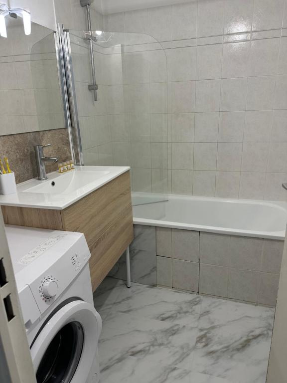 a bathroom with a sink and a washing machine at Appartement gare Plaisir grignon in Plaisir