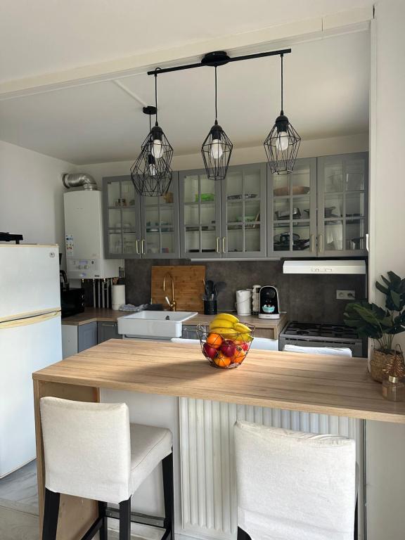 a kitchen with a counter with a bowl of fruit on it at Appartement gare Plaisir grignon in Plaisir