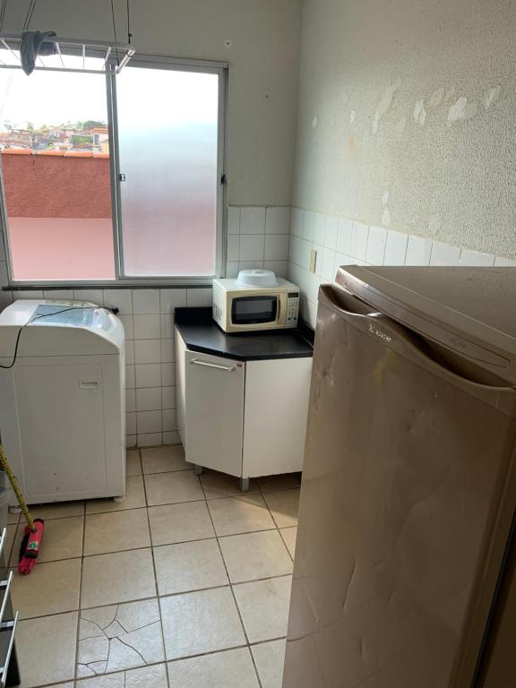 a kitchen with a microwave sitting on top of a counter at Apartamento funcional in Varginha