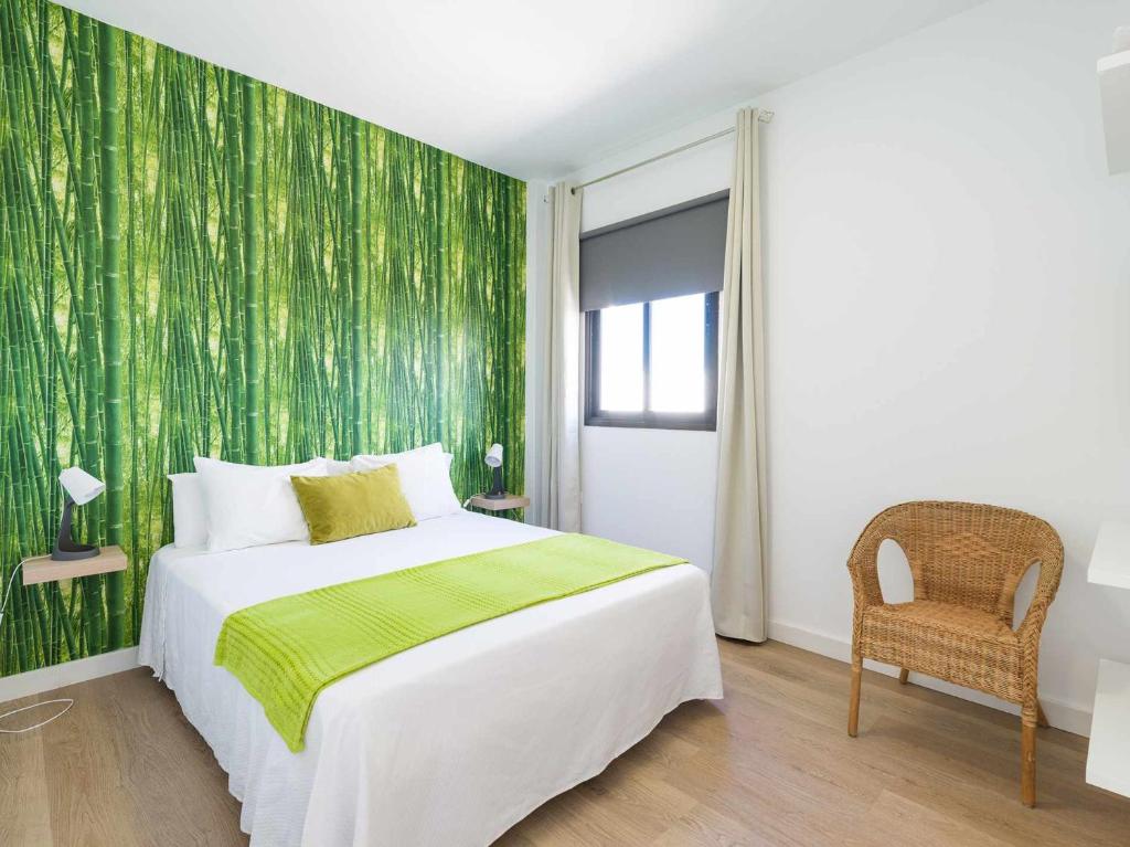 アレシーフェにあるMahostly Apartamento Comillas SEの緑の壁、ベッド付きのベッドルーム1室