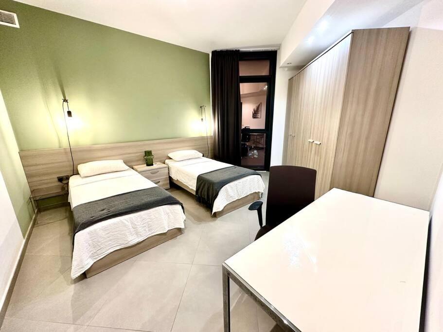um quarto de hotel com duas camas e uma mesa em Stunning 2BR APT w/Pool&Garden em St. Julian's