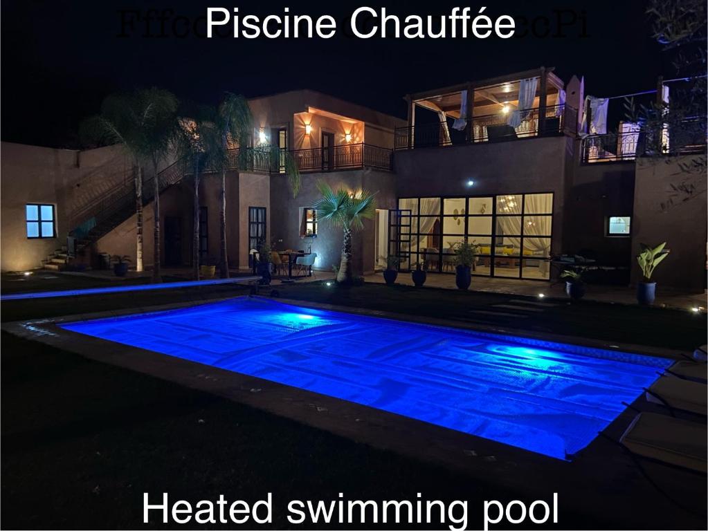 una gran piscina azul por la noche en Villa Scil de luxe 3 Suites Piscine chauffée Hamam Jacuzzi extérieur avec vue sur l'Atlas 2 Parkings Privé en Marrakech