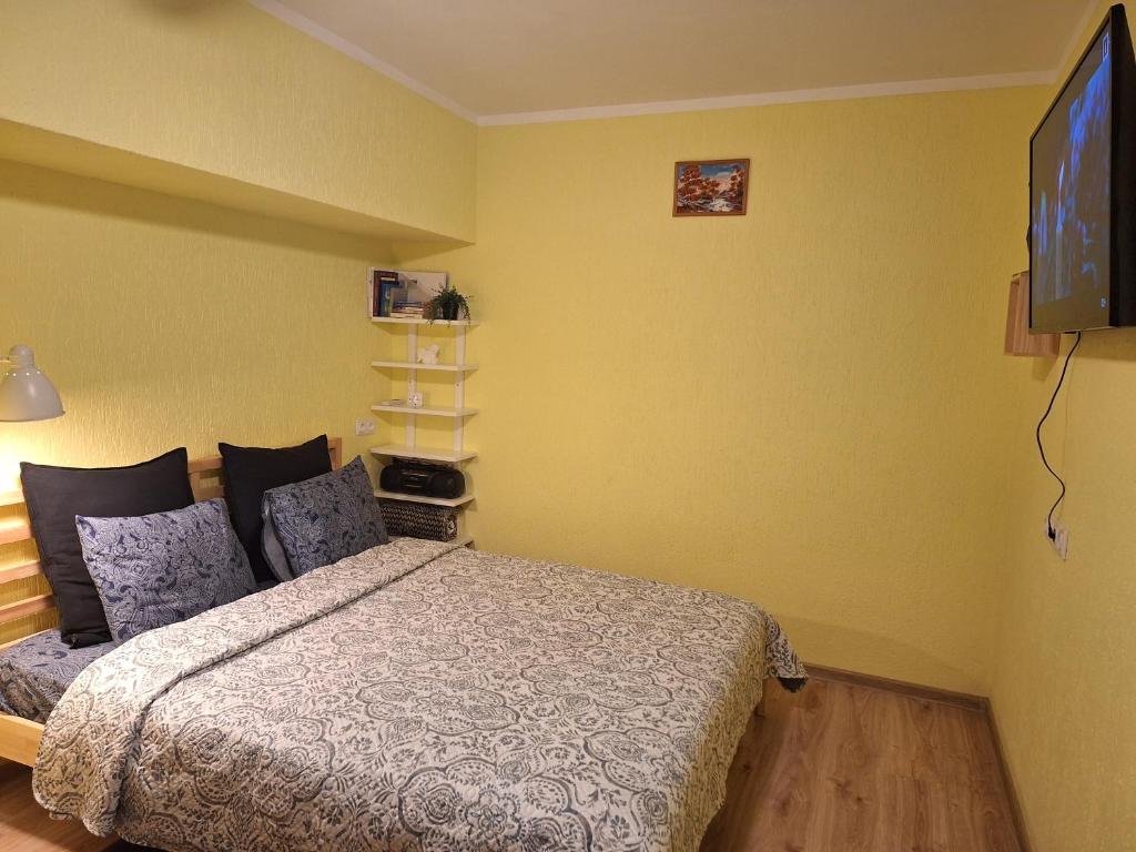 a bedroom with a bed and a flat screen tv at Sunrise Apartment in Madona