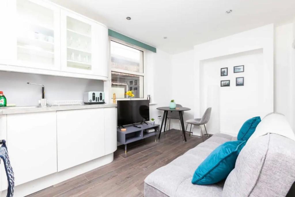 Sala de estar blanca con sofá y mesa en Relaxing Oasis 1BR by the Sea by Sullivan Stays en Brighton & Hove