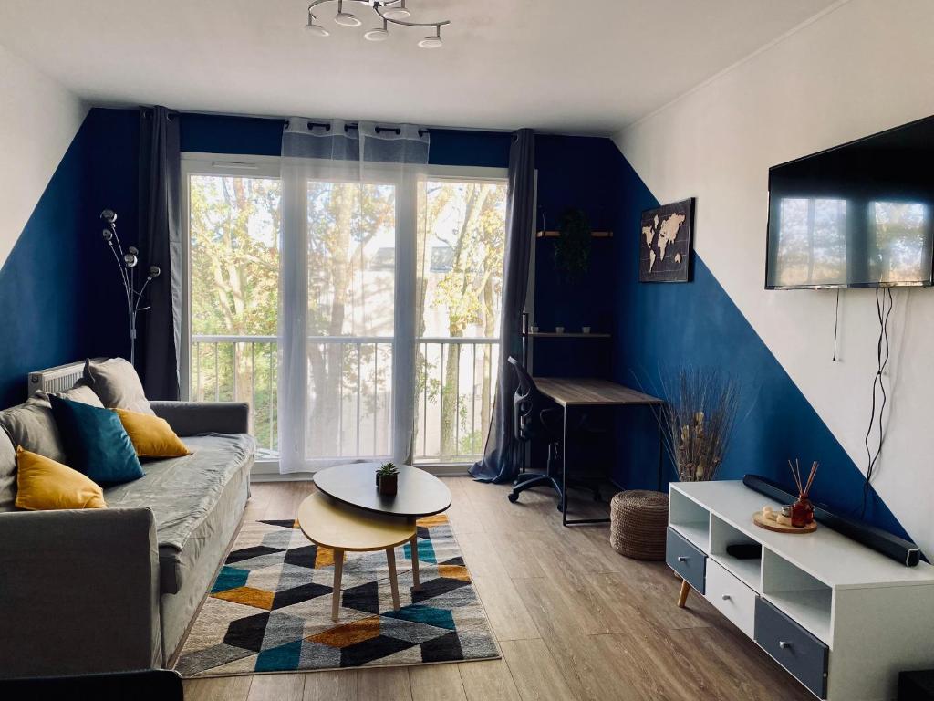 een woonkamer met een bank en een tafel bij Cocoon citadin : Appartement 2 pièces au coeur d'Evry in Évry-les-Châteaux