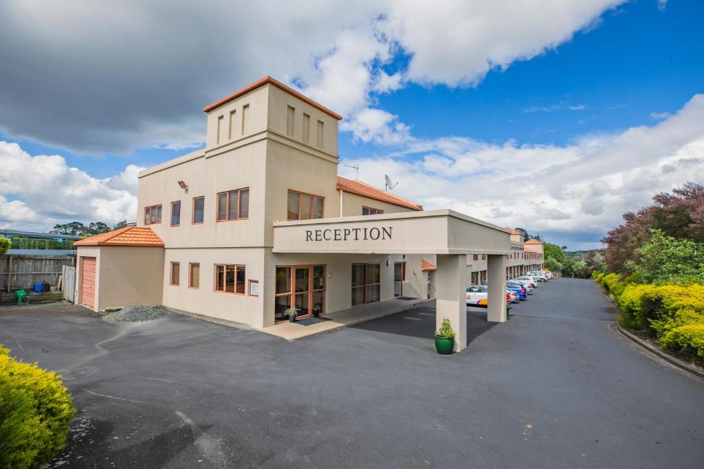 an exterior view of a hotel with a parking lot at Albany Executive Motor Inn Limited in Auckland