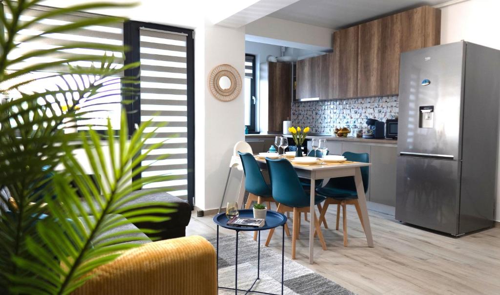 Il comprend une cuisine et un salon avec une table et des chaises. dans l'établissement 'Just like home' Apartment - with Private Parking Place, à Galaţi