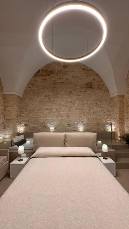 a bedroom with a large white bed and a brick wall at Pietra Antica Luxury in Sannicandro di Bari