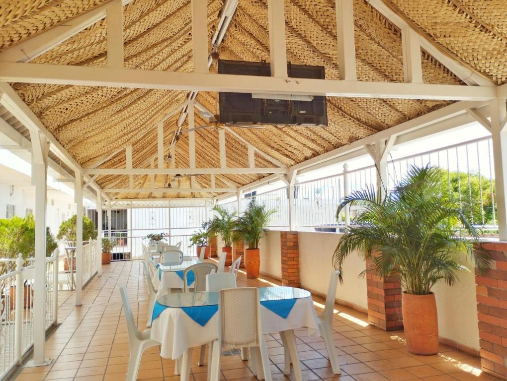 Zimmer mit Tisch und Stühlen in einem Gebäude in der Unterkunft Hotel Orquídea Real in Valledupar