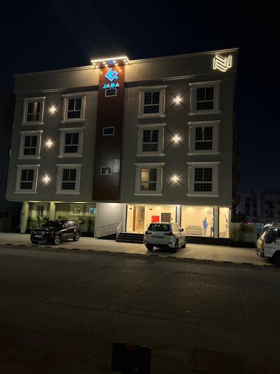 a large building with cars parked in front of it at جادا للشقق المخدومة Jada in Al Khobar