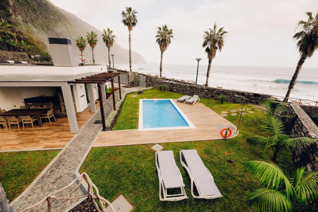 a house with a swimming pool next to the ocean at Casas do Calhau Miúdo - Seixal in Seixal