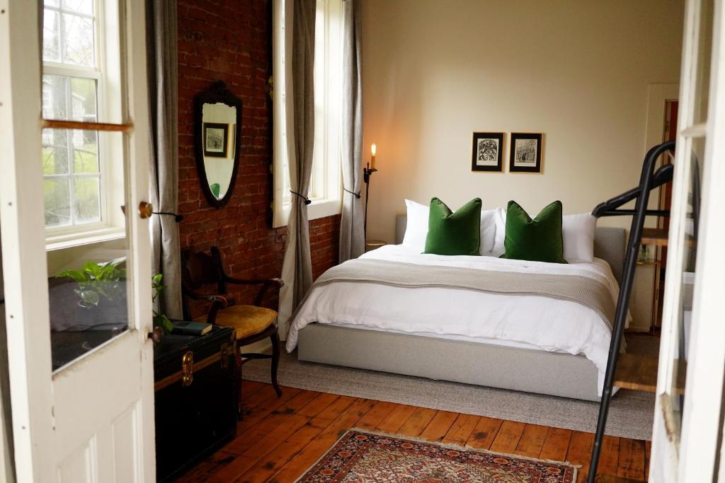 una camera da letto con un letto con cuscini verdi di Imperial Hotel + Restaurant ad Amador City
