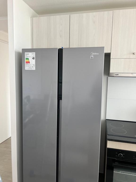 a refrigerator in a kitchen next to a stove at Departamento Reñaca alto in Viña del Mar