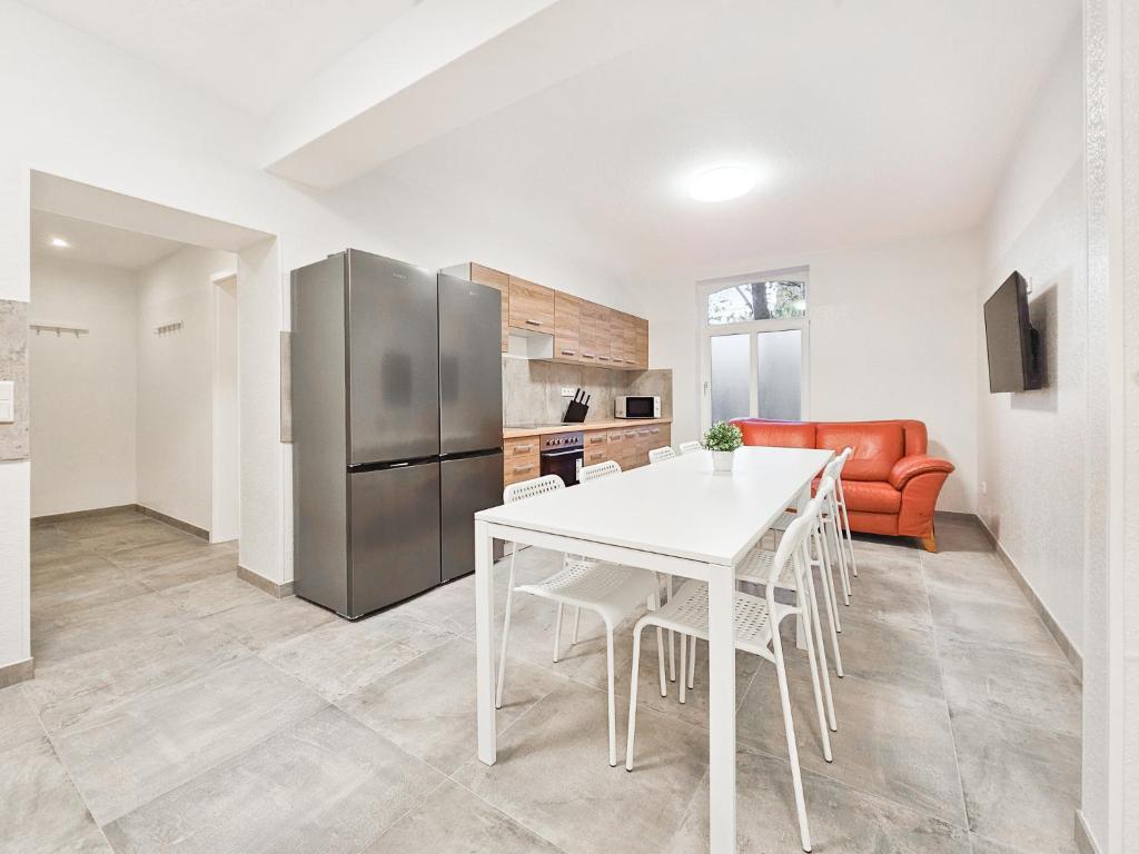 a kitchen with a white table and a refrigerator at Tolstov Apartments - 3 , 4 and 5 Room Apartments - 20 Min zur Messe DUS in Willich