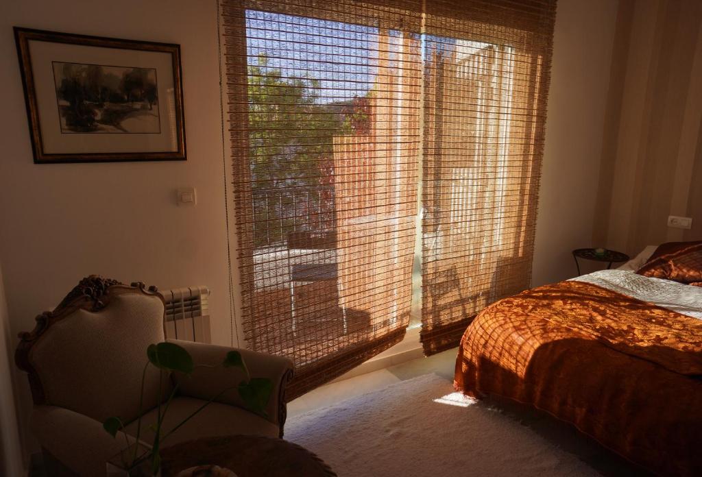 a bedroom with a window and a bed and a chair at Cute and relaxing bed and breakfast en Albayzín in Granada
