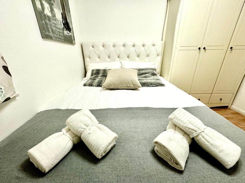 a bedroom with a large bed with two mitts on it at NewDay Property - Chelsea in London