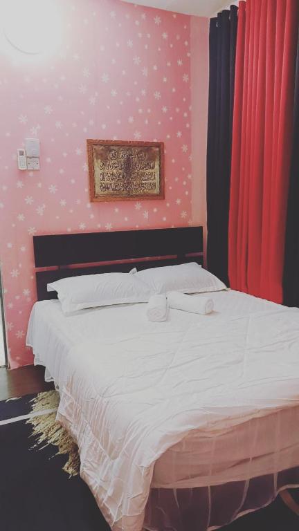 1 dormitorio con 1 cama blanca con lunares en la pared en Lisa homstay, en Jenjarum