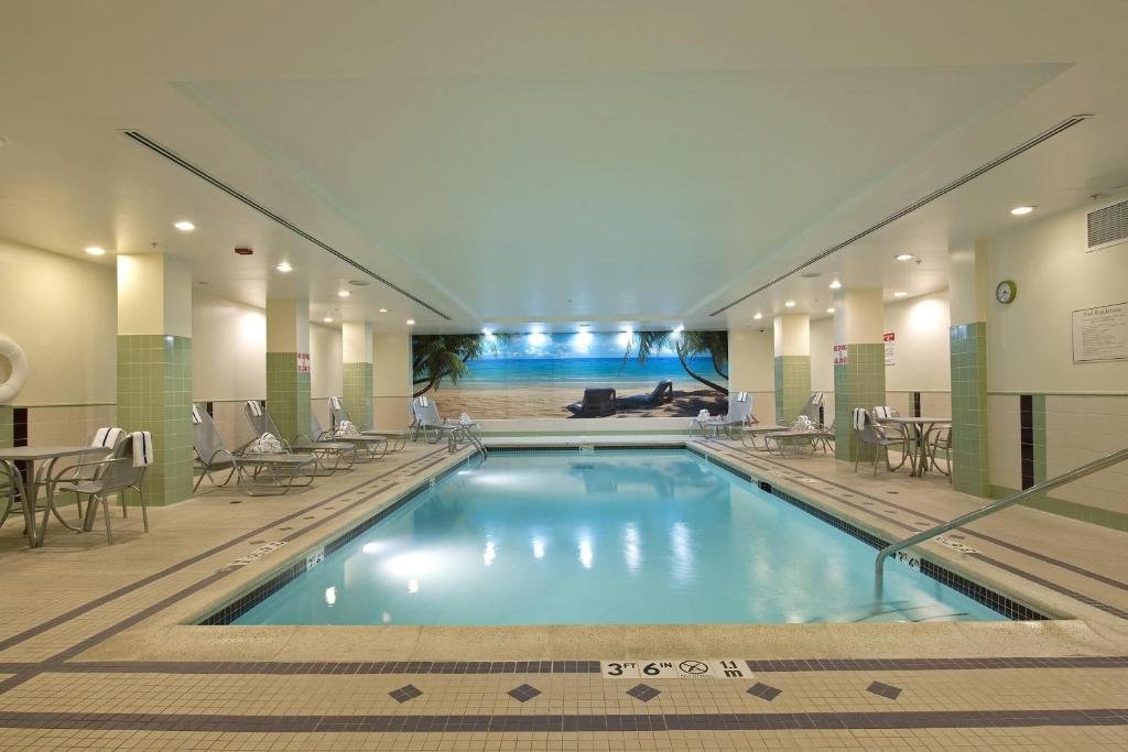 a swimming pool in a hotel with tables and chairs at SpringHill Suites by Marriott Chicago O'Hare in Rosemont