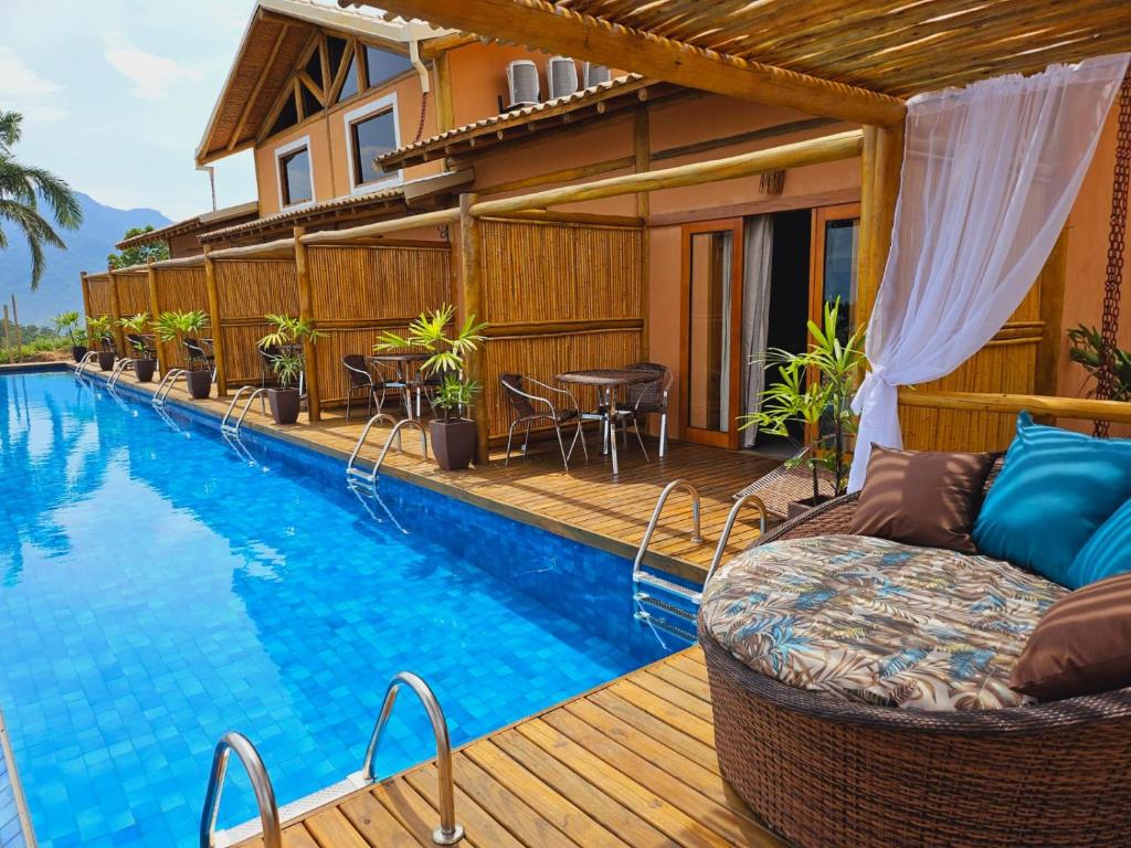 een huis met een zwembad op een houten terras bij Tahaa Pousada Boutique in Ilhabela