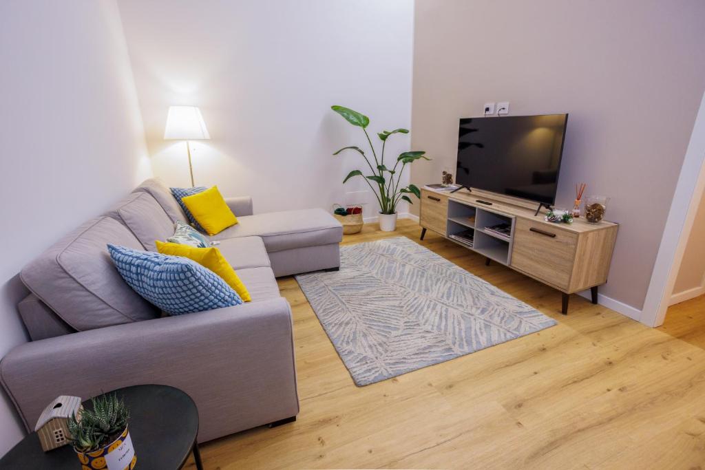 sala de estar con sofá y TV de pantalla plana en Feltrinelli Suite, en Módena