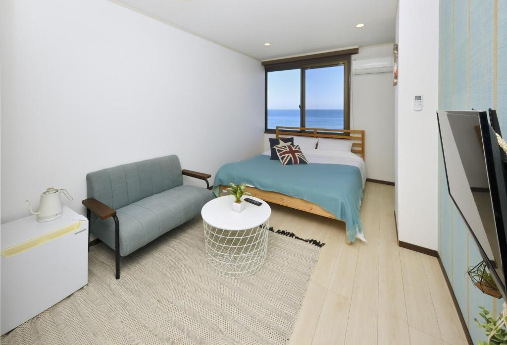 a bedroom with a bed and a couch and a chair at seaside villa HILIFE - Vacation STAY 99018 in Kogushi