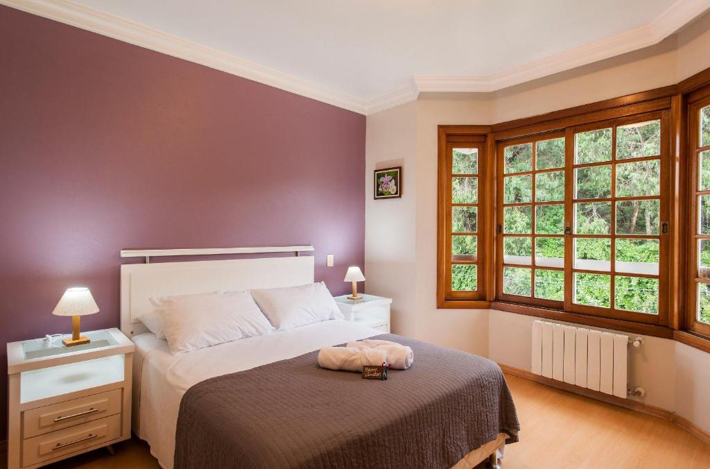 una camera con un letto e due finestre di LOCAR-IN GRAMADO - Duplex Solar da Borges a Gramado