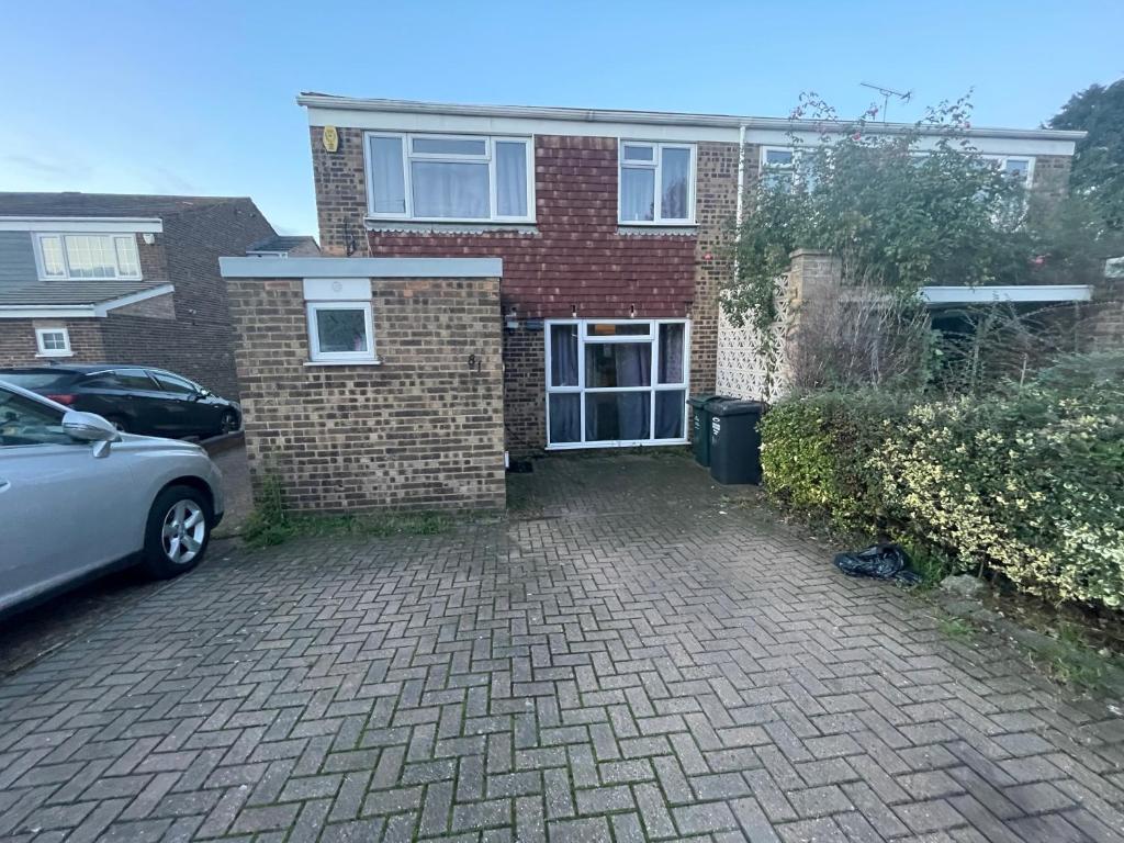 a brick house with a car parked in front of it at Bowman’s Place Cosy Lodge in Kent