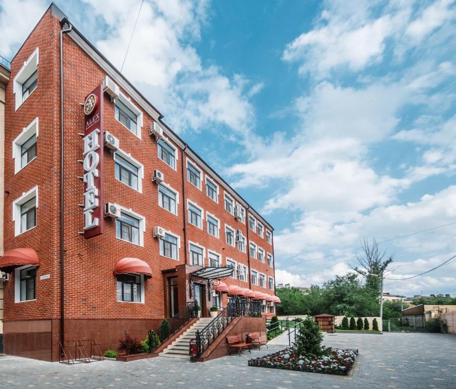 a red brick building with a sign on it at Alex Residence Hotel in Volzhsky