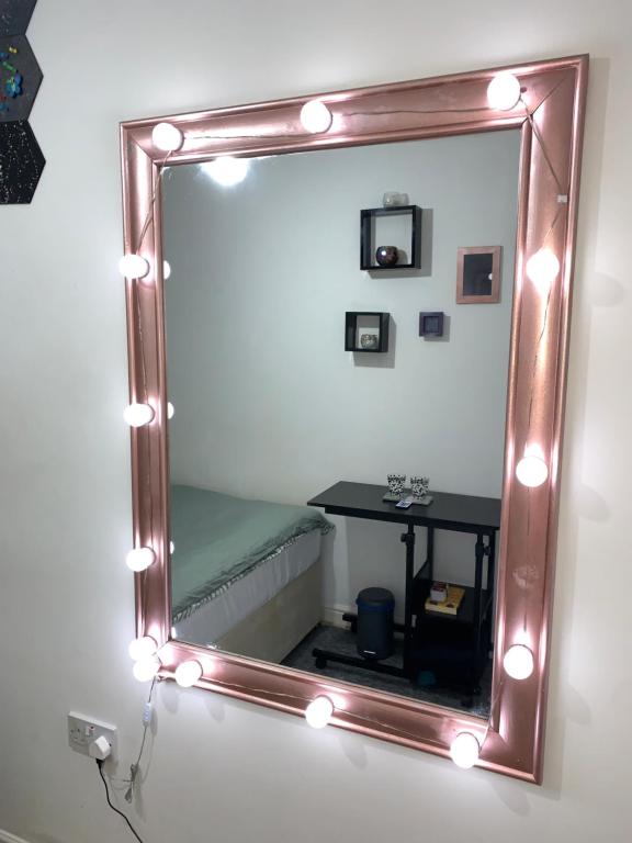 a mirror with lights and a table in a room at Private Room in shared Apartment Free Parking -20min to Manchester in Manchester