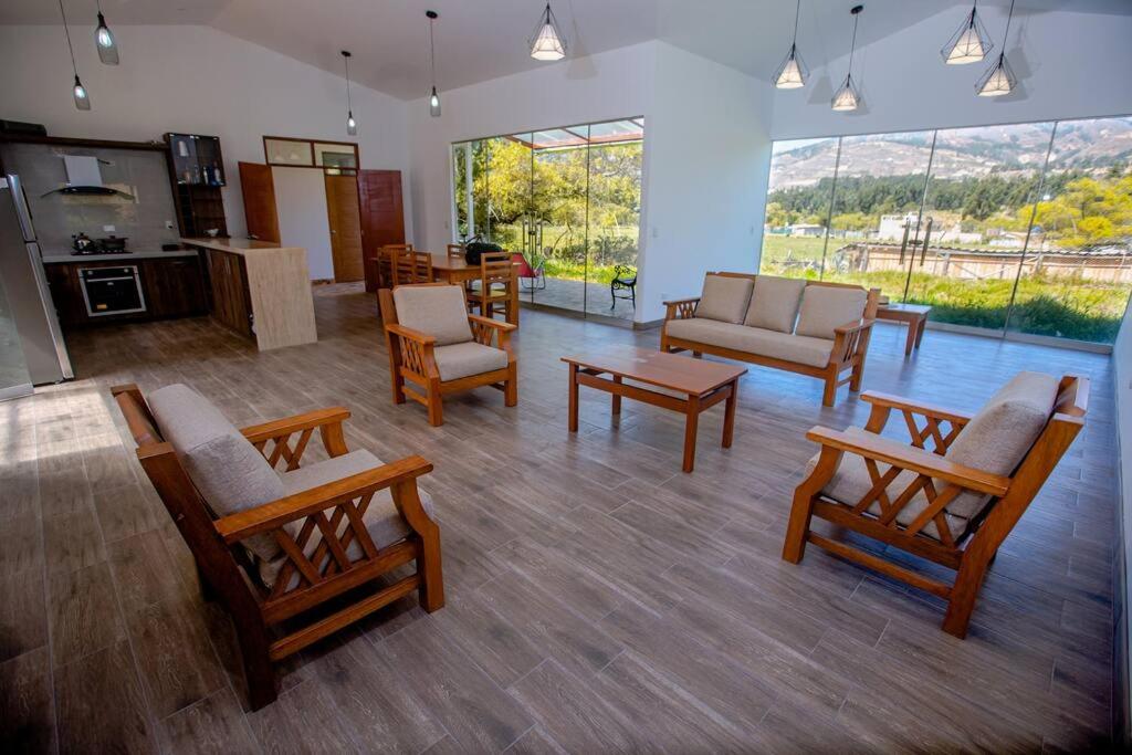 una gran sala de estar con sillas de madera y una mesa. en La Casa de Luiz - Casa de Campo, 