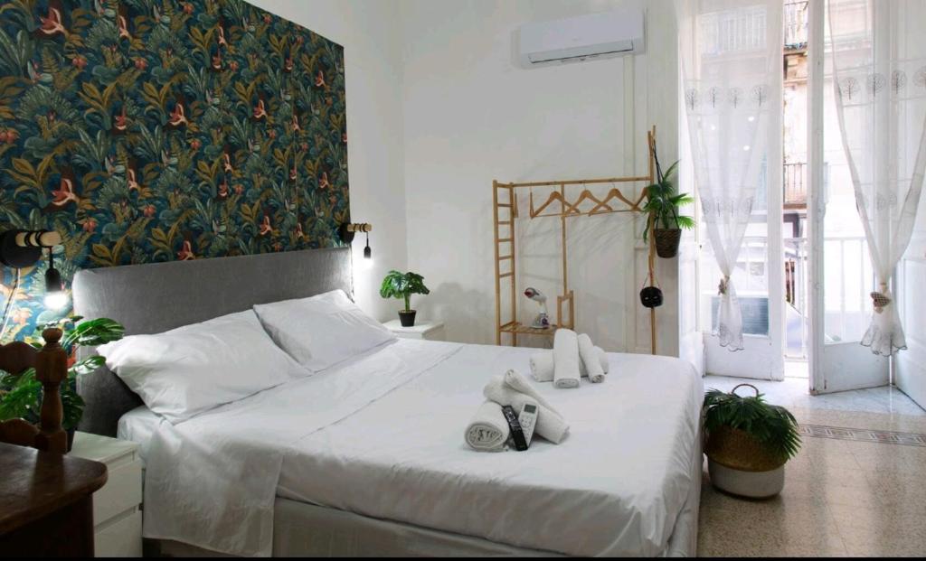 una camera da letto con un grande letto bianco con scarpe di Grey Room 'Historic Centre' a Napoli