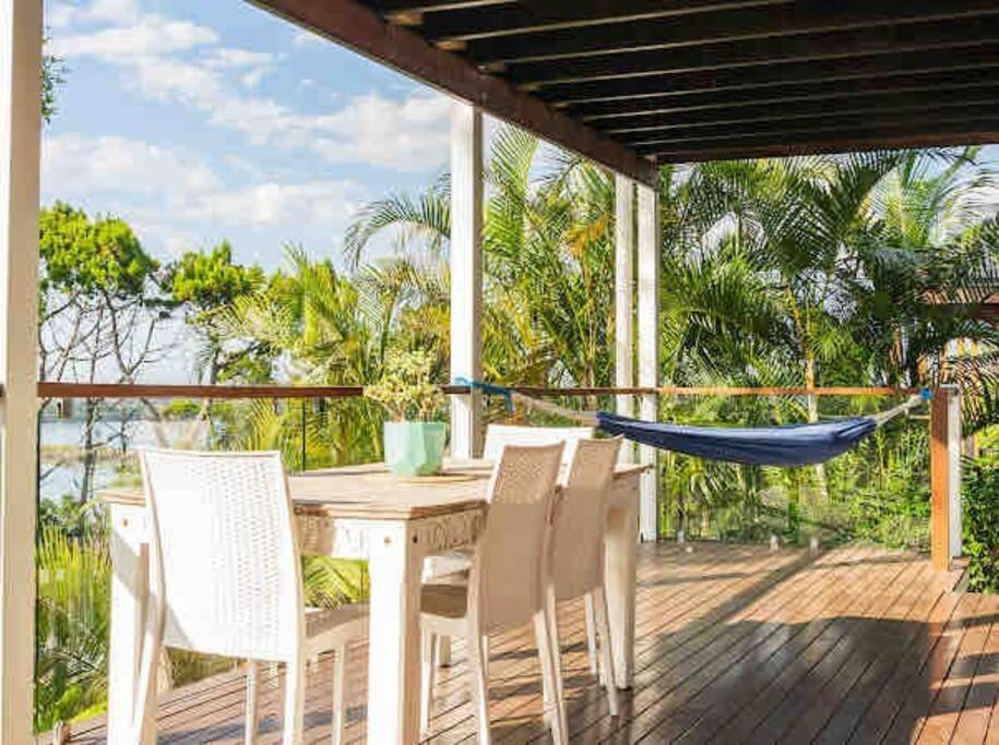 a table and chairs on a deck with a hammock at DRIFTWOOD- Hidden Gem, great view in a nature setting in East Ballina