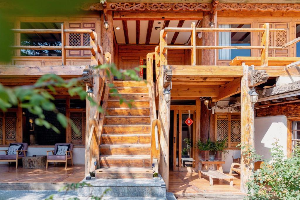 Un escalier en bois mène à une maison. dans l'établissement Courtyard Shangri-la 藏舍小院, à Shangri-La