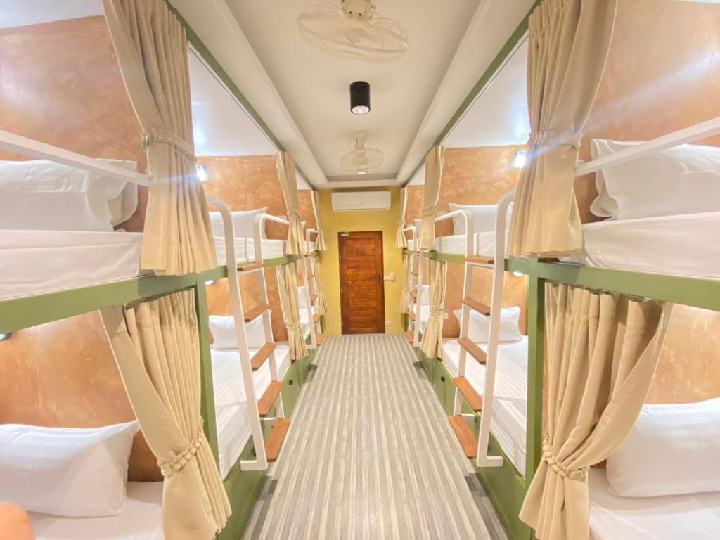 un couloir d'un train avec des lits superposés dans l'établissement Sierra Hostel, à Nai Yang Beach