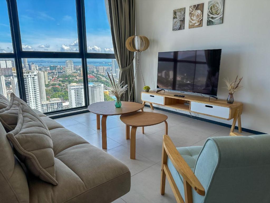 a living room with a couch and a tv at Cozy Urban Suites Georgetown View in Jelutong