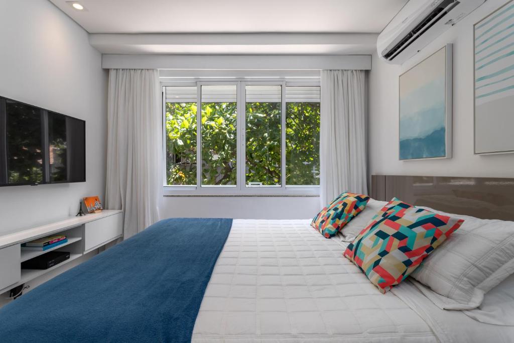 um quarto com uma cama grande e uma janela grande em Fantastic sea view - Maison Ipanema Prime no Rio de Janeiro