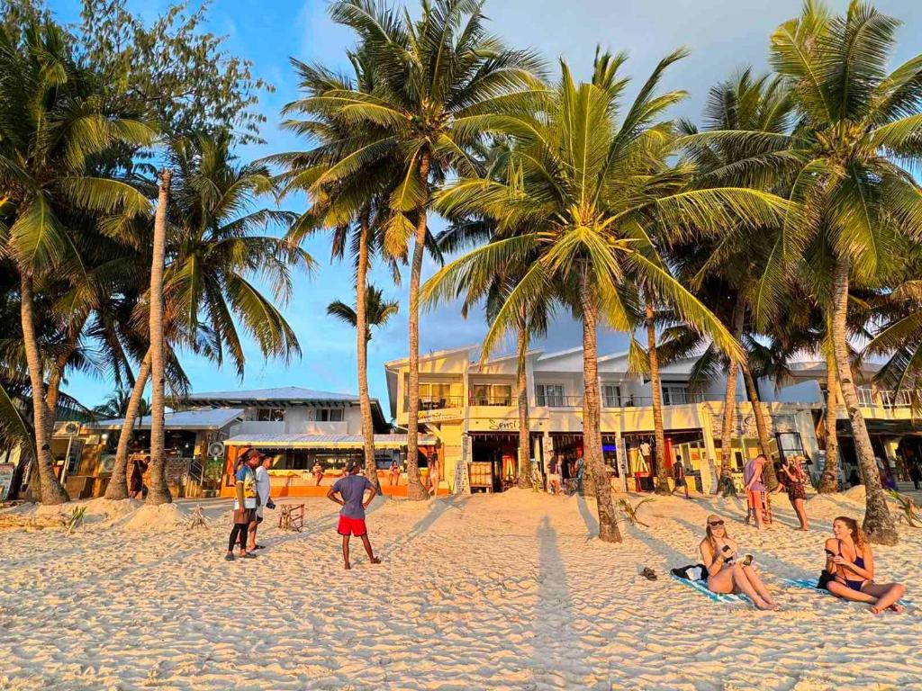 a group of people on a beach with palm trees at Calypso Beach and Dive Resort in Boracay
