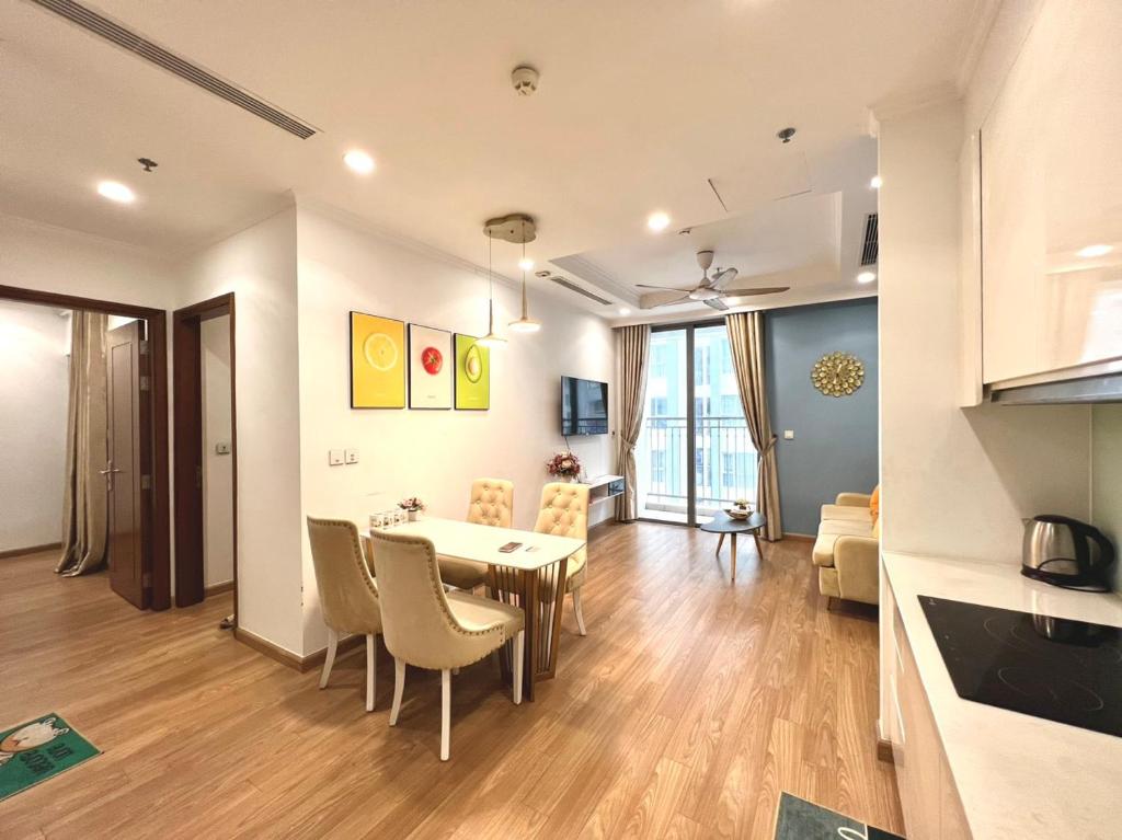 cocina y sala de estar con mesa y sillas en BOM HOMES- VINHOMES TIMES CITY- 2BR- PARK hill, en Hanói