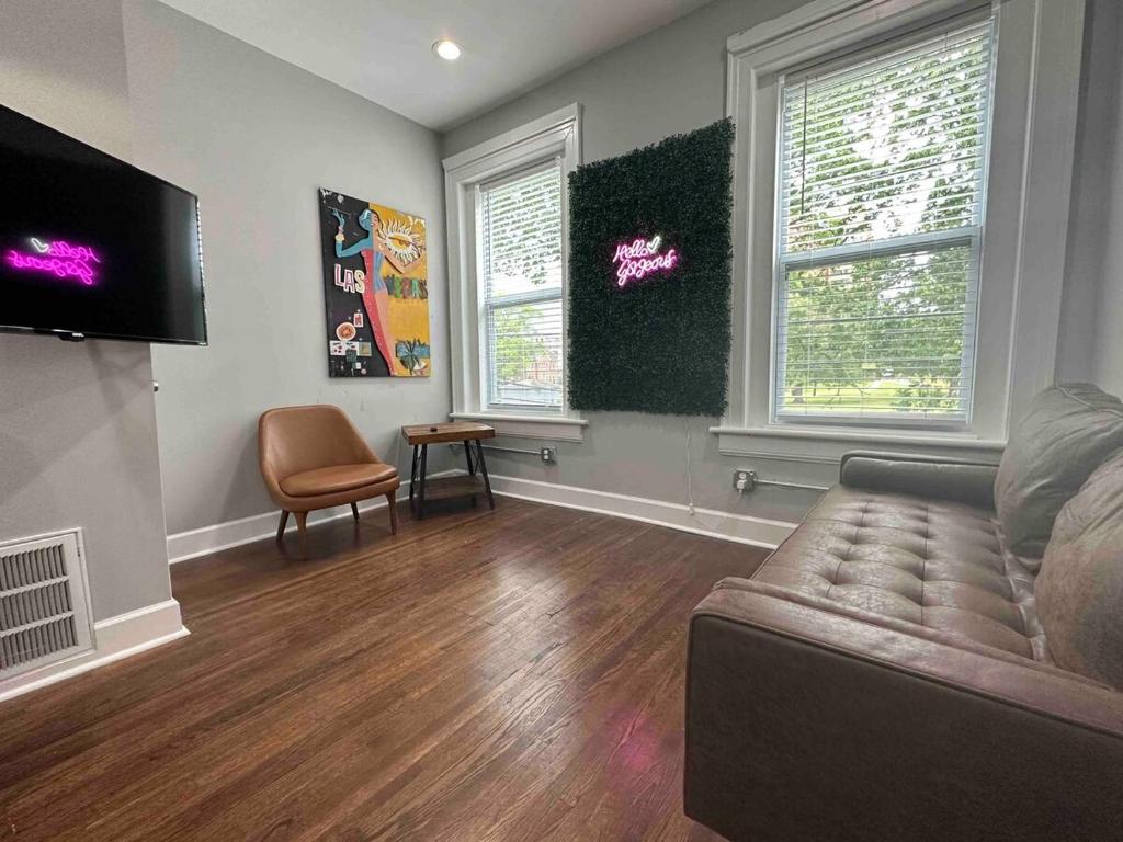 uma sala de estar com um sofá e duas janelas em Westend Two Stylish & Cozy em Nashville
