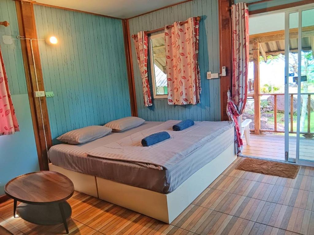 - une chambre avec un lit, une table et une fenêtre dans l'établissement The Ngam Kho Resort, à Ko Kood