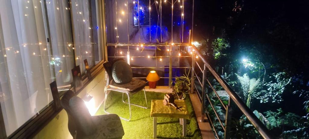a room with a balcony with lights on it at Private & Cosy 2 BHK with Homely Kitchen, Balcony-Garden View -Solo,Couple & Group Friendly Central Delhi,Hauz Khas,AIIMS,INA in New Delhi