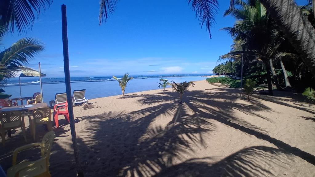 een strand met palmbomen en een tafel en stoelen bij Blue pearl in Beruwala